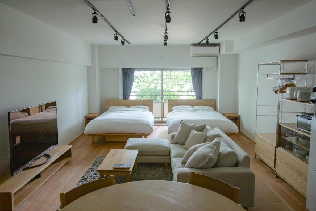 NIYS apartments 08 type في طوكيو: غرفة معيشة بها سريرين وأريكة