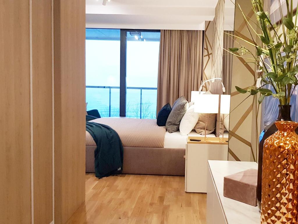sypialnia z łóżkiem i dużym oknem w obiekcie APARTLUX Seaside Park - bezpośredni widok na morze w Kołobrzegu