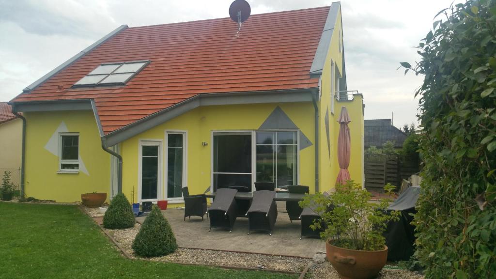 une maison jaune avec une table et des chaises dans la cour dans l'établissement Moderne großzügige Villa 246 qm 8,5 Zimmer, offener Kamin bis zu 13 Schlafplätze, à Obergröningen