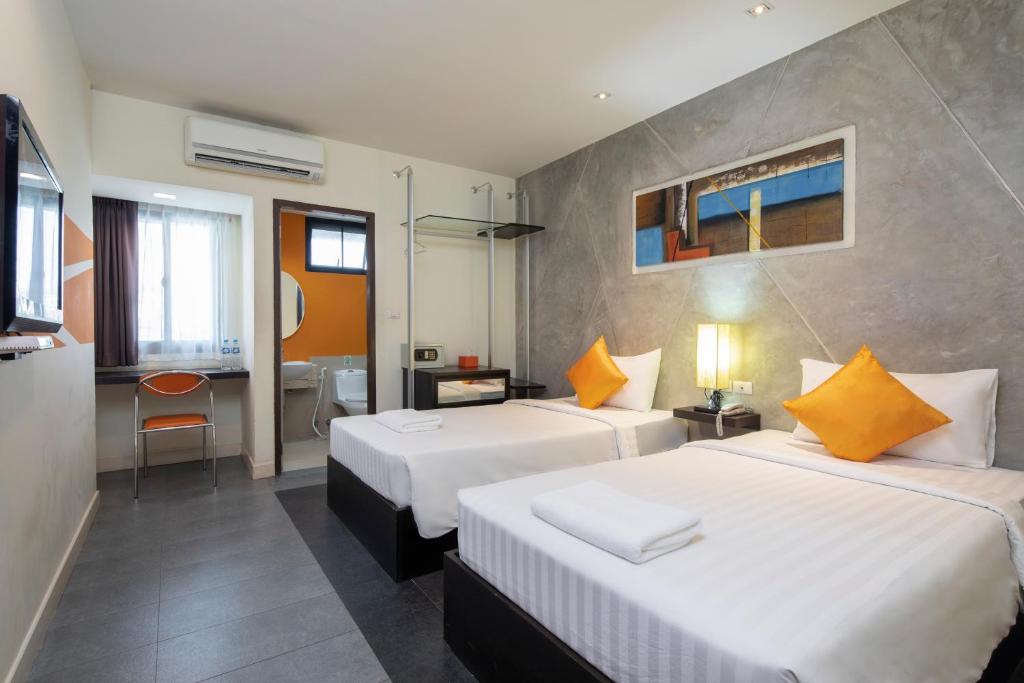 a hotel room with two beds and a bathroom at @ Border Hotel, Aranyaprateth in Aranyaprathet