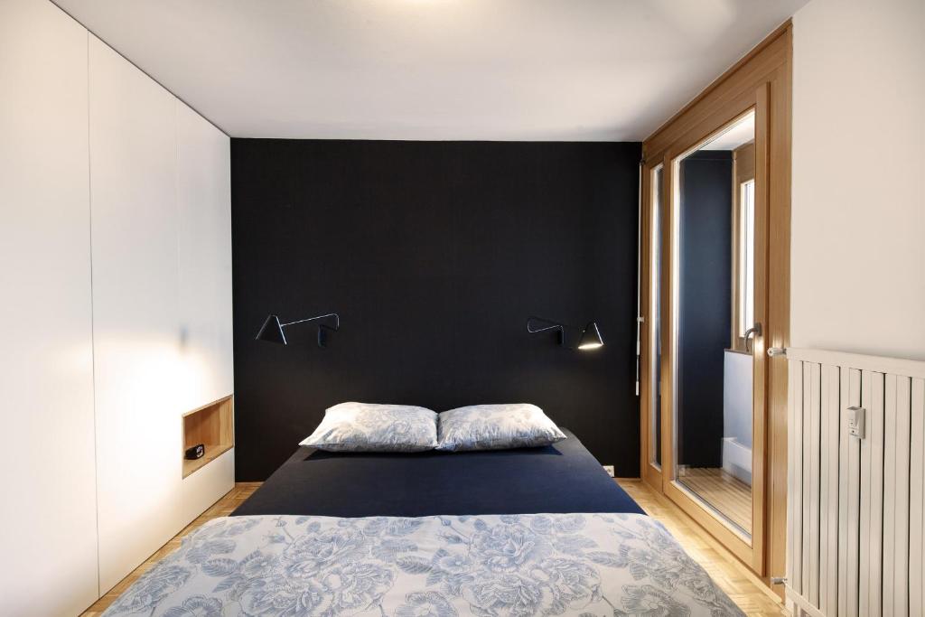 ein Schlafzimmer mit einer schwarzen Wand und einem Bett in der Unterkunft Bright Penthaus Apartement, with a wonderful view in Ljubljana