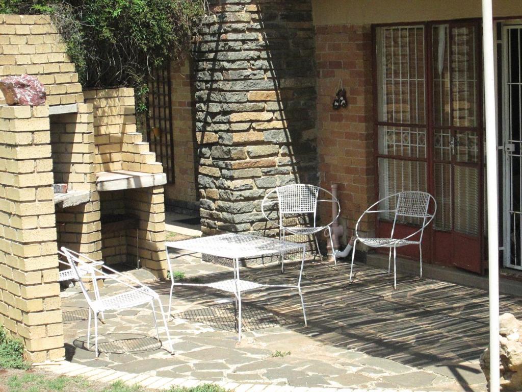 un grupo de sillas y una mesa en un patio en Bedrock B&B, en Bloemfontein