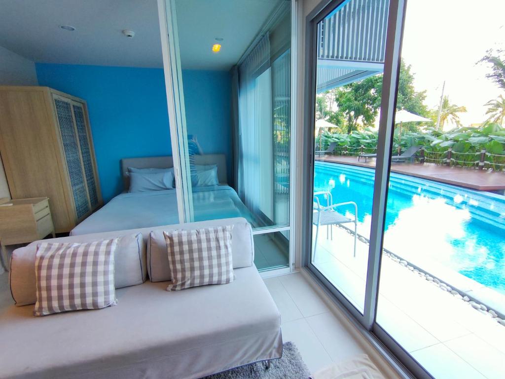 a bedroom with a bed and a swimming pool at BLU-Pool Access in Cha Am