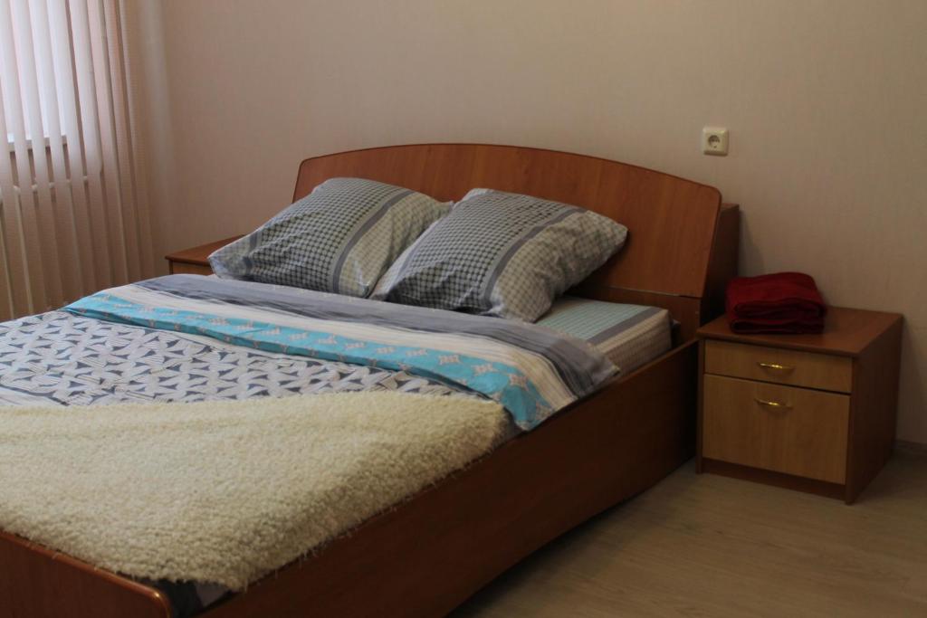 チュメニにあるСолнечный Аквапаркのベッド(木製のヘッドボード、ナイトスタンド付)