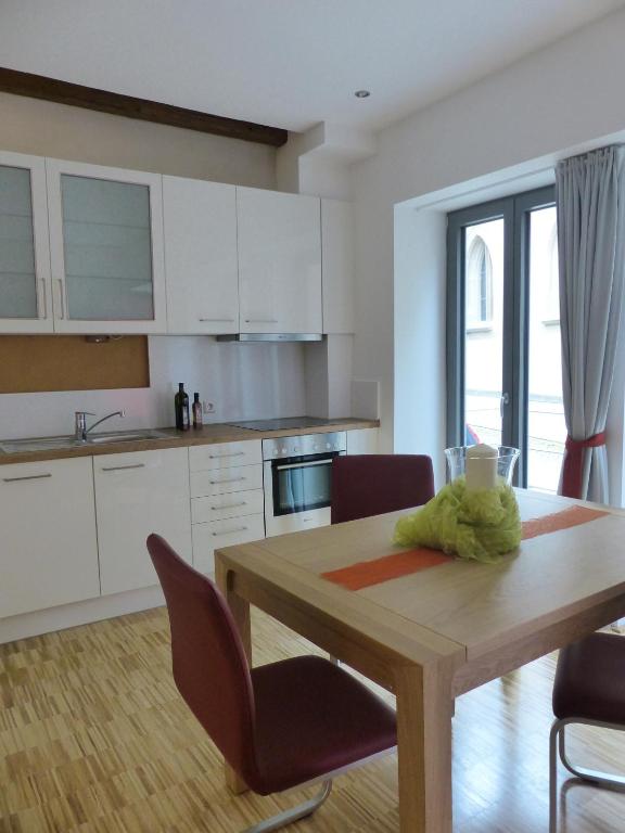 a kitchen with a wooden table and a table and chairs at Nagelschmiede in Münsingen