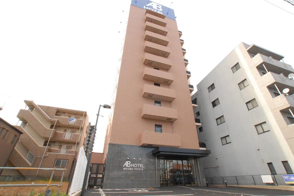 a tall building next to two tall buildings at AB Hotel Mikawa Toyota in Toyota