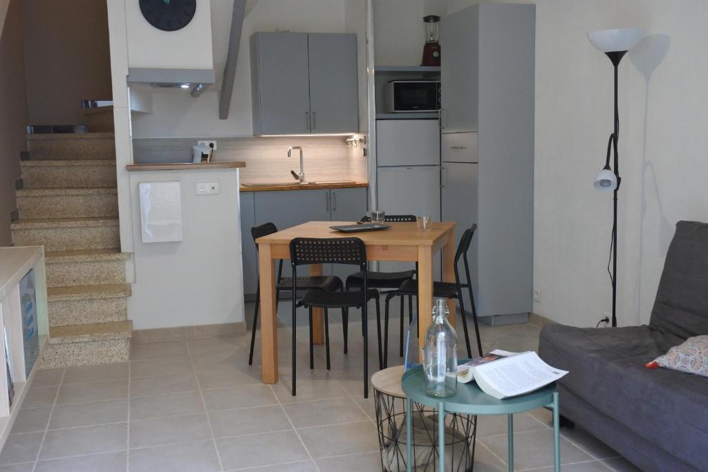 Il comprend un salon avec une table et une cuisine. dans l'établissement Maison du 14.07, à Arles