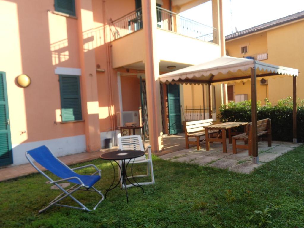 une terrasse avec des chaises, une table et un parasol dans l'établissement lidoapartment, à Fano