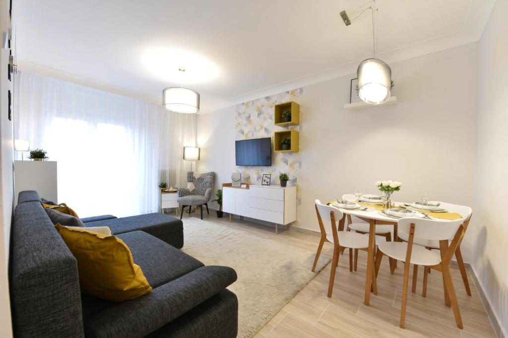 uma sala de estar com um sofá e uma mesa de jantar em Királykút 1 apartman - ingyen parkolás, bicajok, ac em Székesfehérvár