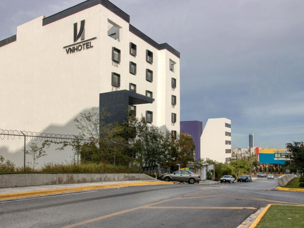 un edificio blanco con un cartel en una calle en VN Hotel, en Monterrey