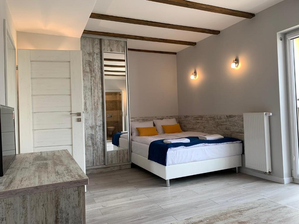 um quarto com uma cama com almofadas azuis e laranja em Willa Atlantis em Mielno