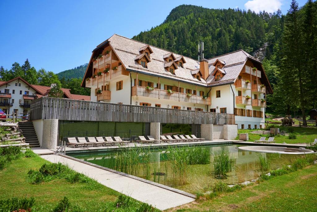 - un grand bâtiment avec une piscine en face dans l'établissement Hotel Plesnik Logarska Dolina, à Solčava