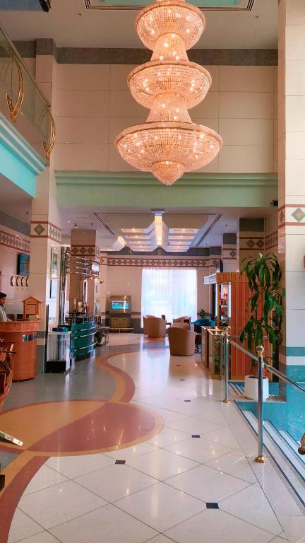 a large lobby with chandeliers in a building at Spark Residence Hotel in Sharjah