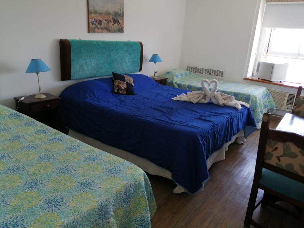 sypialnia z 2 łóżkami i niebieskimi kołdrami w obiekcie Aguas del Monte Hotel SPA w mieście San Miguel del Monte