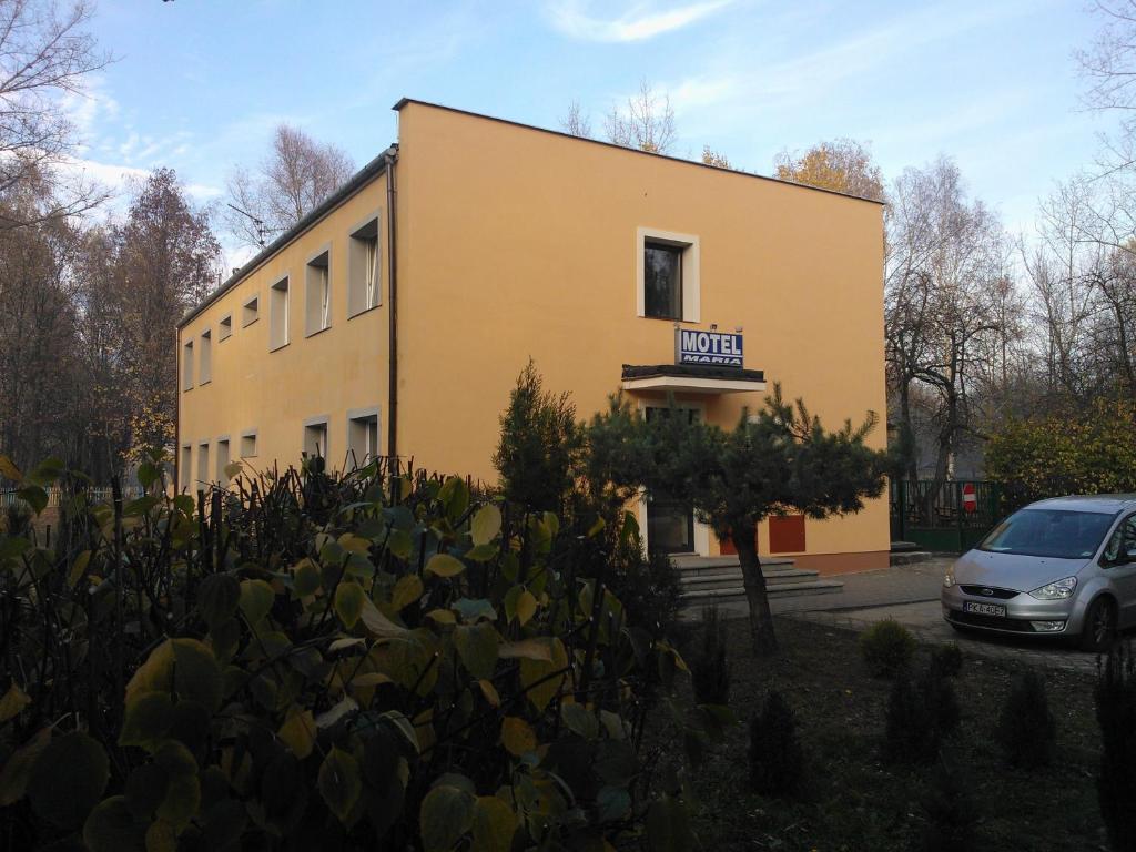 a building with a car parked in front of it at Motel Maria in Szałe