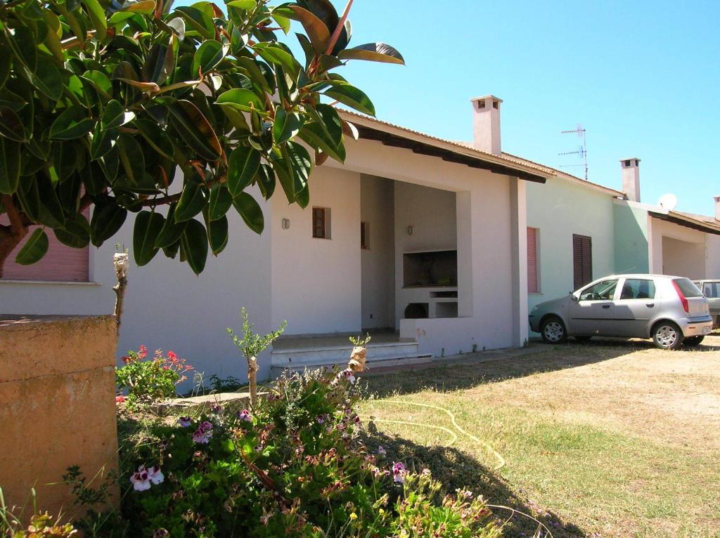 una casa con un coche aparcado delante de ella en Casa Vacanza Isola Rossa, en Trinità dʼAgultu