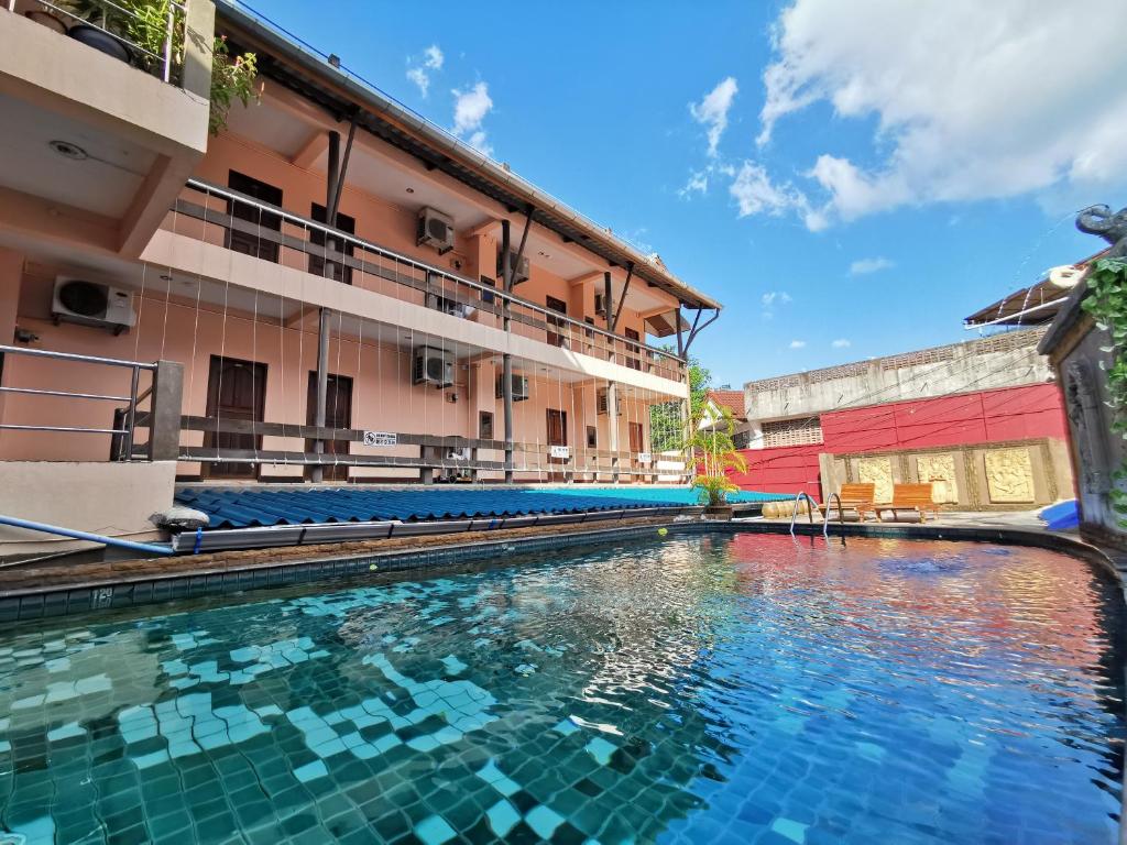 a swimming pool in front of a building at Baan Veerakit Hotel in Patong Beach