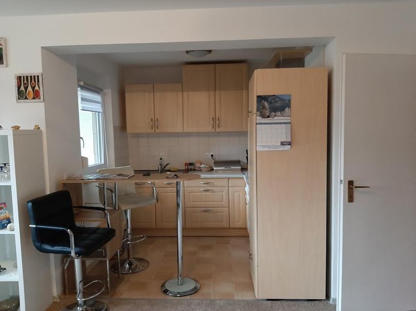 a kitchen with a refrigerator and a table and chairs at Monteurswohnung Monteurunterkunft in Heilbronn