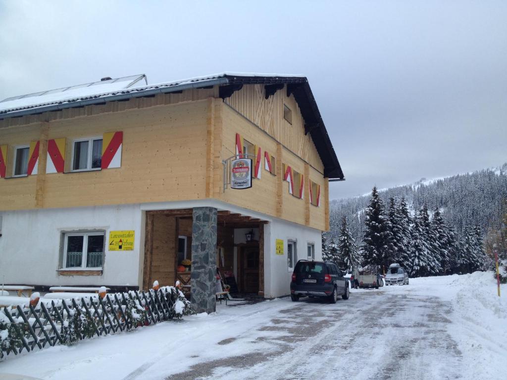 um grande edifício com um sinal na neve em Alpengasthaus Sonnhof em Goding