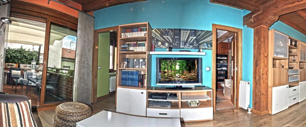 a living room with a tv and bookshelves at Apartamentos Sabor Rural II in León