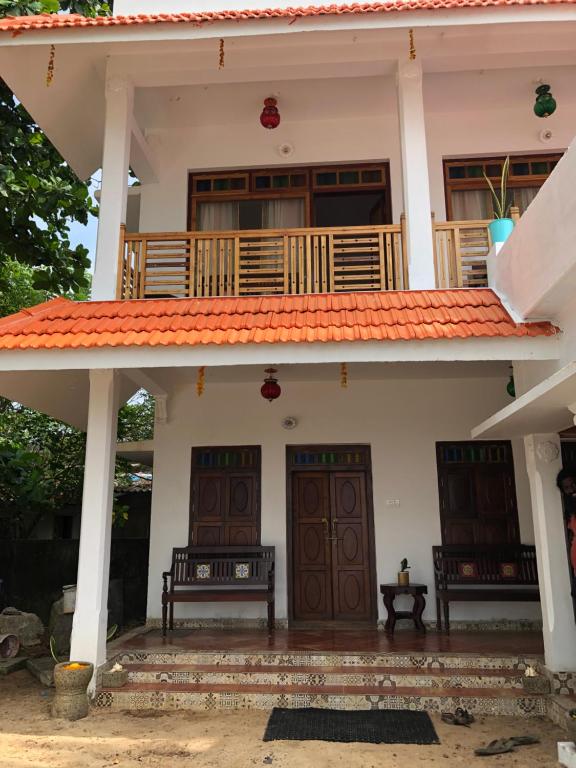 Alleppey的住宿－Lemon Dew Beach House, Alleppey Beach，前面有两长椅的房子