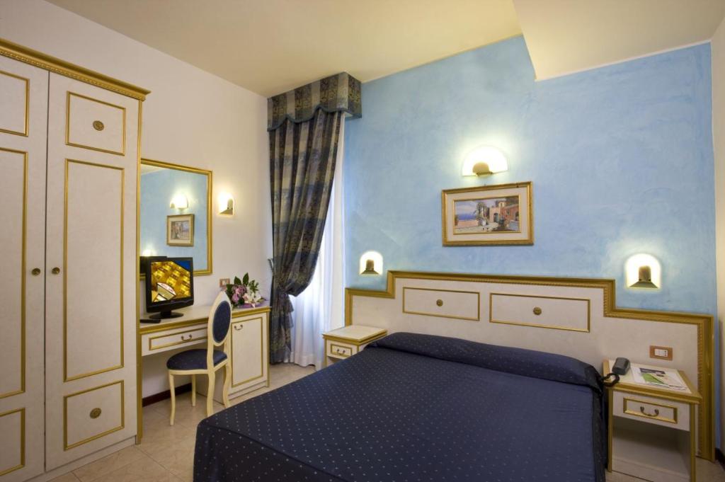 Cette chambre comprend un lit bleu et un bureau. dans l'établissement Hotel King, à Rimini