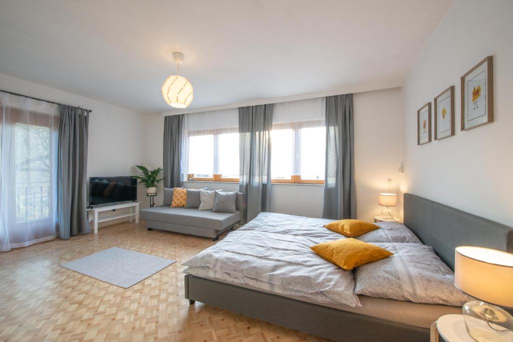 a bedroom with a large bed and a living room at Haus Karl in Ebensee