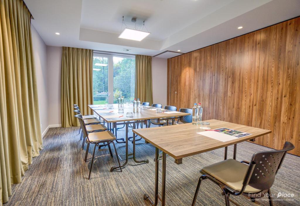 a conference room with wooden walls and tables and chairs at Utopia Hotel - Art & Nature Hotel in Mons