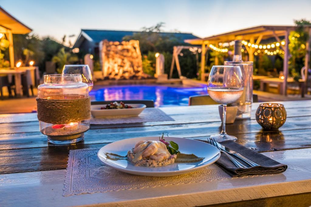 een tafel met een bord eten en een glas wijn bij Red Palm Village in Kralendijk