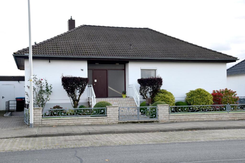 ein weißes Haus mit einem Zaun davor in der Unterkunft FeWo Afferde in Hameln