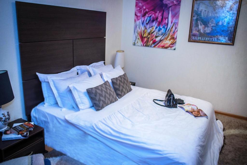 1 dormitorio con 1 cama blanca grande con máscara en ORNAVA Boutique Apartments, en Ternopilʼ