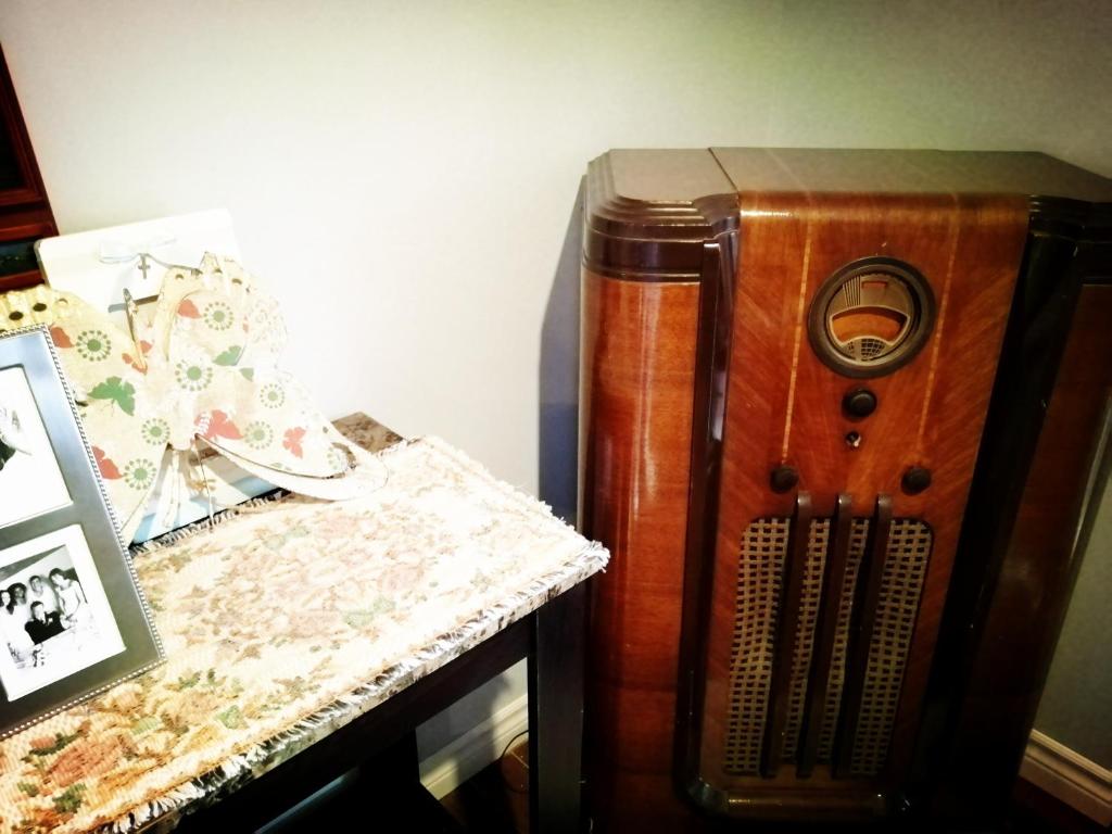 an old wooden speaker sitting next to a table at Lily's garden in Charlottetown