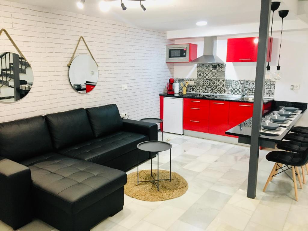 a living room with a black couch and red cabinets at Fabuloso Loft en Centro Histórico de Córdoba. Tendillas-Mezquita-Catedral. in Córdoba