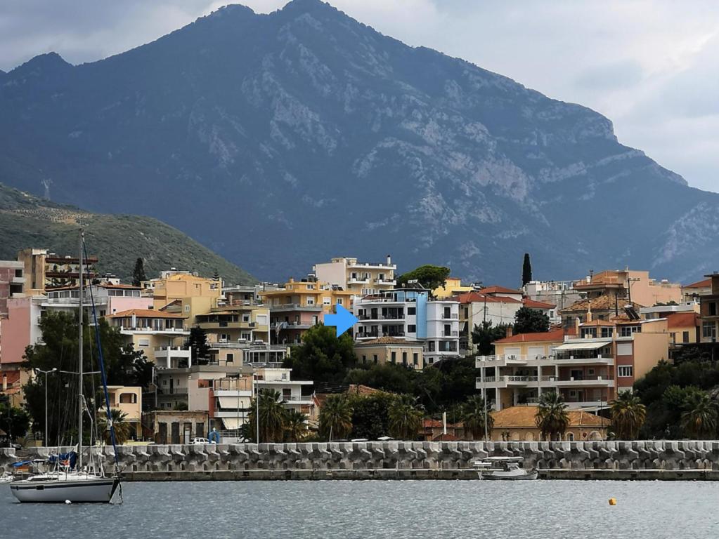 eine Stadt mit einem Berg im Hintergrund und einem Boot im Wasser in der Unterkunft Magical Seaside Town Boutique Apts 2 in Kyparissia
