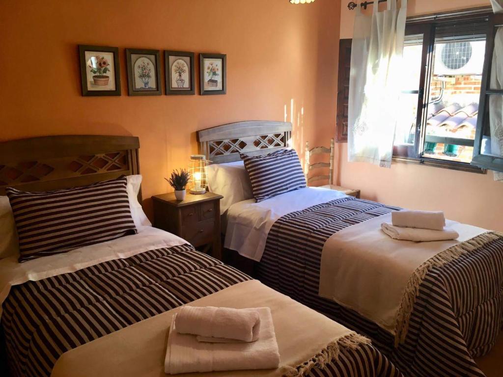 a bedroom with two beds and a window at Apartamento La Alcancía in Toledo