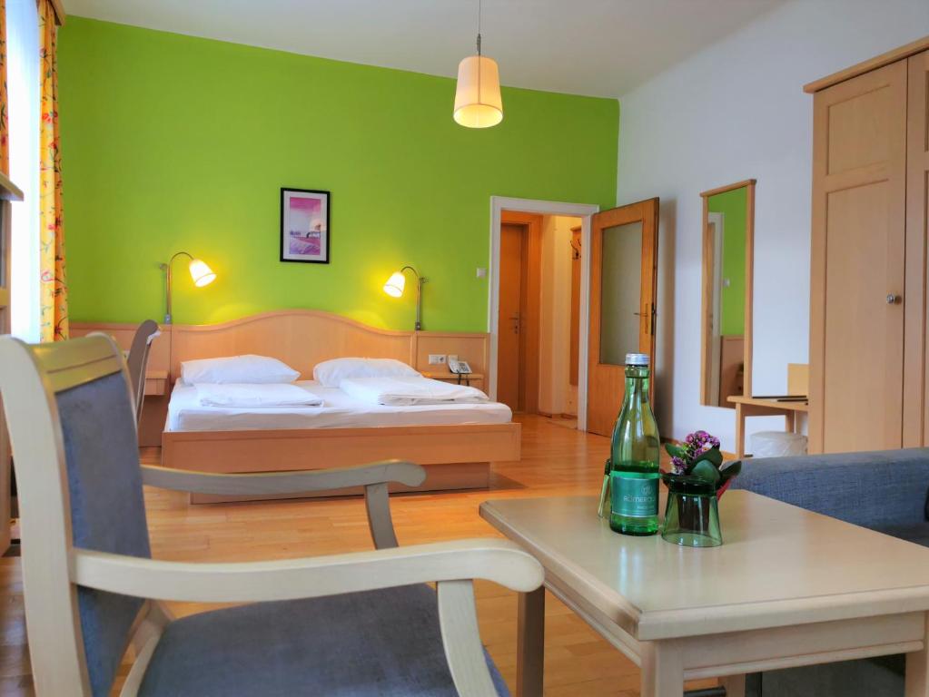 una camera con un letto e un tavolo con una bottiglia sopra di Belvedere a Semmering