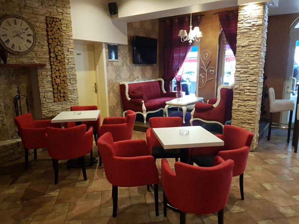 um restaurante com cadeiras e mesas vermelhas e um relógio em Prenociste Lane em Ključ