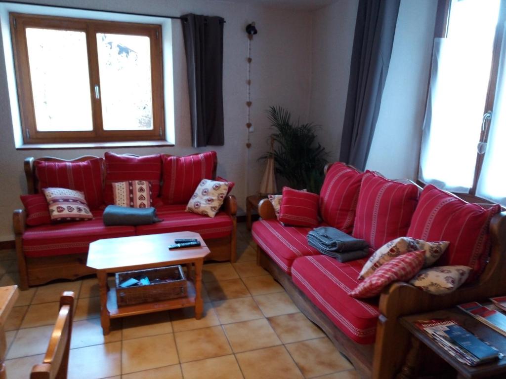 una sala de estar con sofás rojos y una mesa. en appartement Landry, en Landry