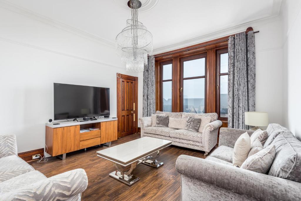 a living room with two couches and a tv at Claymore Apartment Broughty Ferry in Dundee