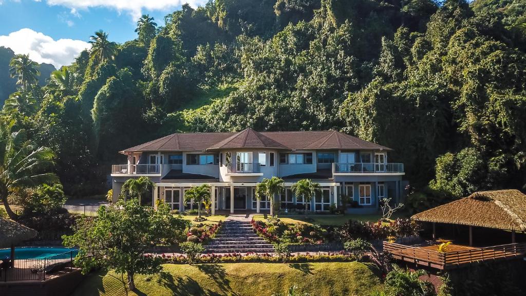 a house with a mountain in the background at Iro Luxury Retreat in Rarotonga