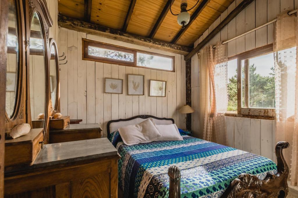 um quarto com uma cama, um lavatório e um espelho em La Cabañita de José Ignacio em José Ignacio