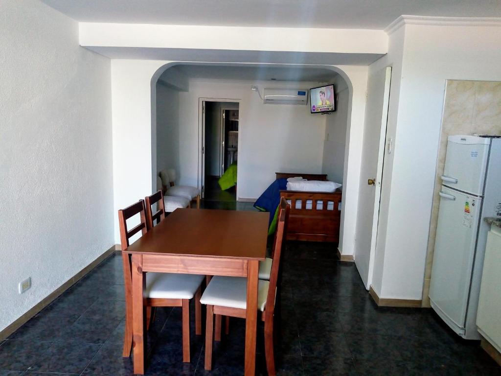 Habitación con mesa, sillas y cocina. en Departamento Colón 2 en San Rafael