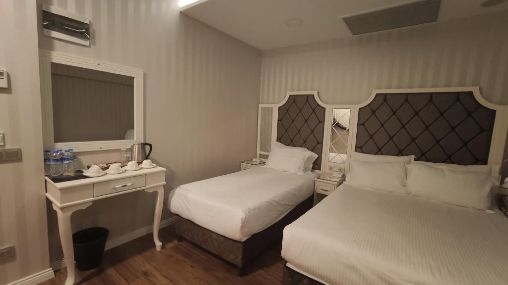 a small bedroom with two beds and a mirror at Mister Istanbul Hotel & Spa in Istanbul