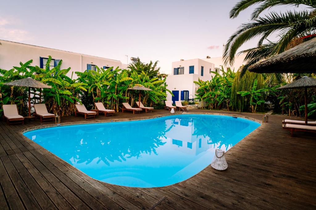 a large blue swimming pool with chairs and umbrellas at Casa Di Roma in Parikia