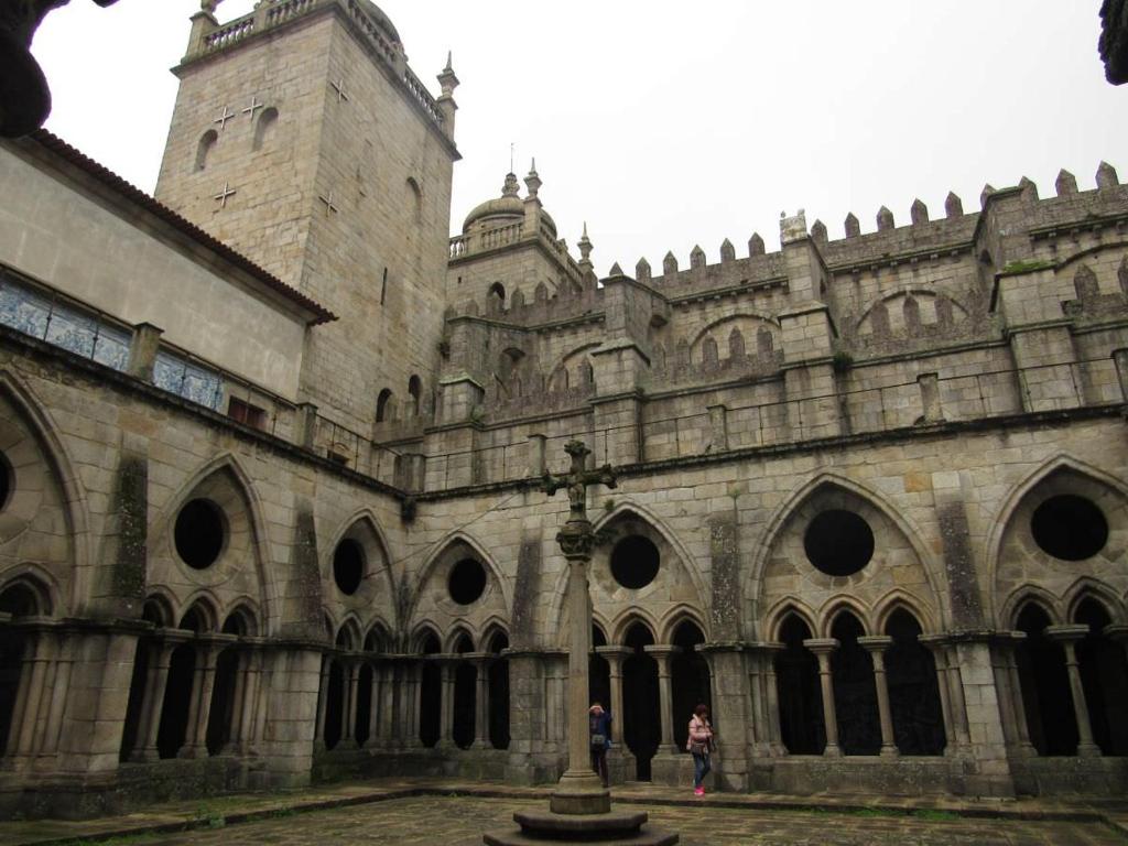a large stone building with a cross in front of it at Guest House Triunfo in Porto