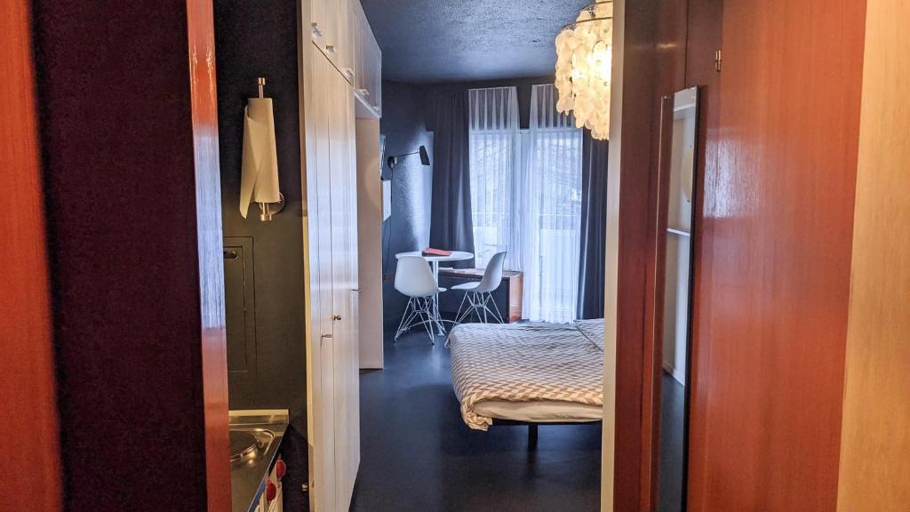 a hallway with a room with a bedroom and a table at Z Studio - next door to Vals Therme in Vals