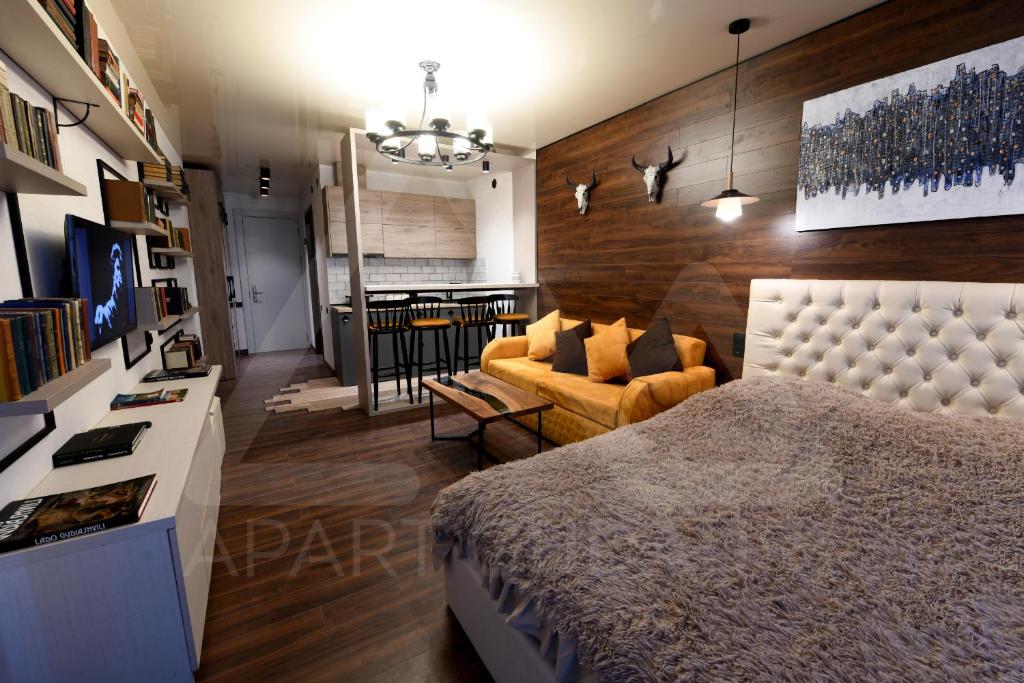 a bedroom with a bed and a living room at New Gudauri Atrium 240 - Apart Gudauri LLC in Gudauri