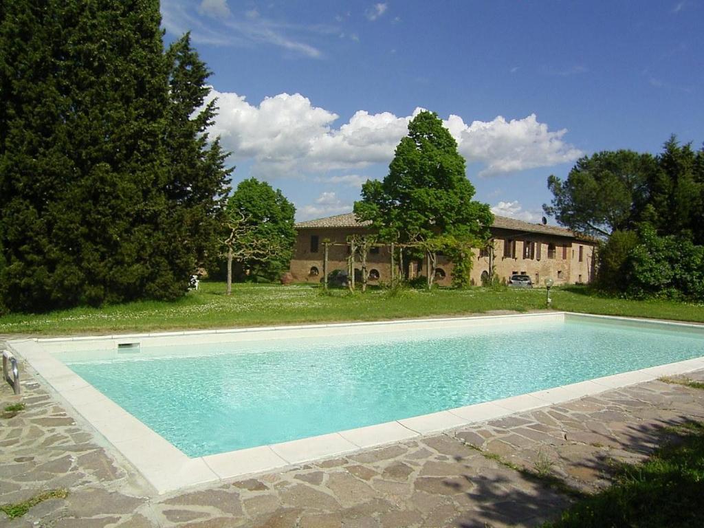 a large swimming pool in front of a house at Villa Poggio al Sole Bio Agriturismo private pool in San Rocco a Pilli