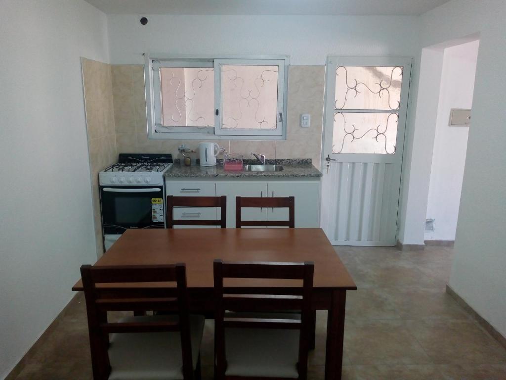 una cocina con mesa de madera y sillas. en Departamento Colón 1, en San Rafael