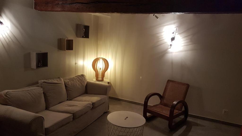 ein Wohnzimmer mit einem Sofa und einem Stuhl in der Unterkunft Appartement au calme in Changis-sur-Marne